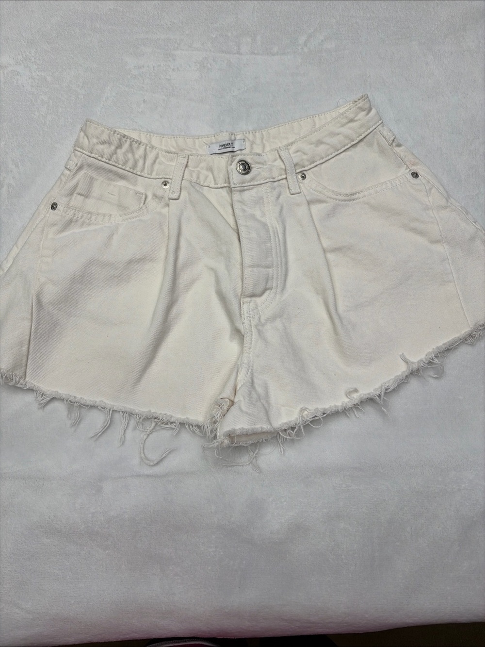 White denim cut-off shorts from Forever 21 featuring a distressed raw hem